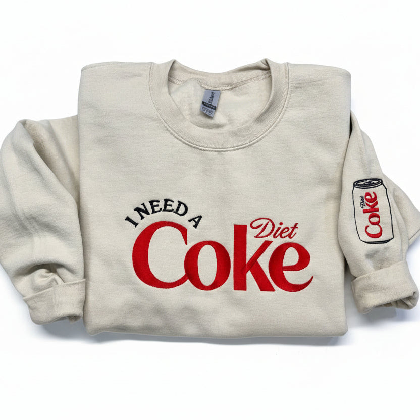 Diet Coke fans. I need a Diet Coke embroidered cozy sweatshirt comes with a mini sized Diet Coke on the sleeve.