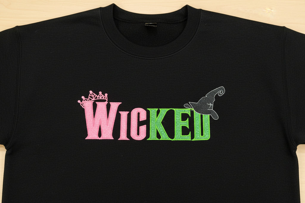 WICKED! This sparkly, embroidered wicked sweatshirt is perfect for Wicked fans. Includes a sleeve embellishment of a Green Broom/Pink Wand