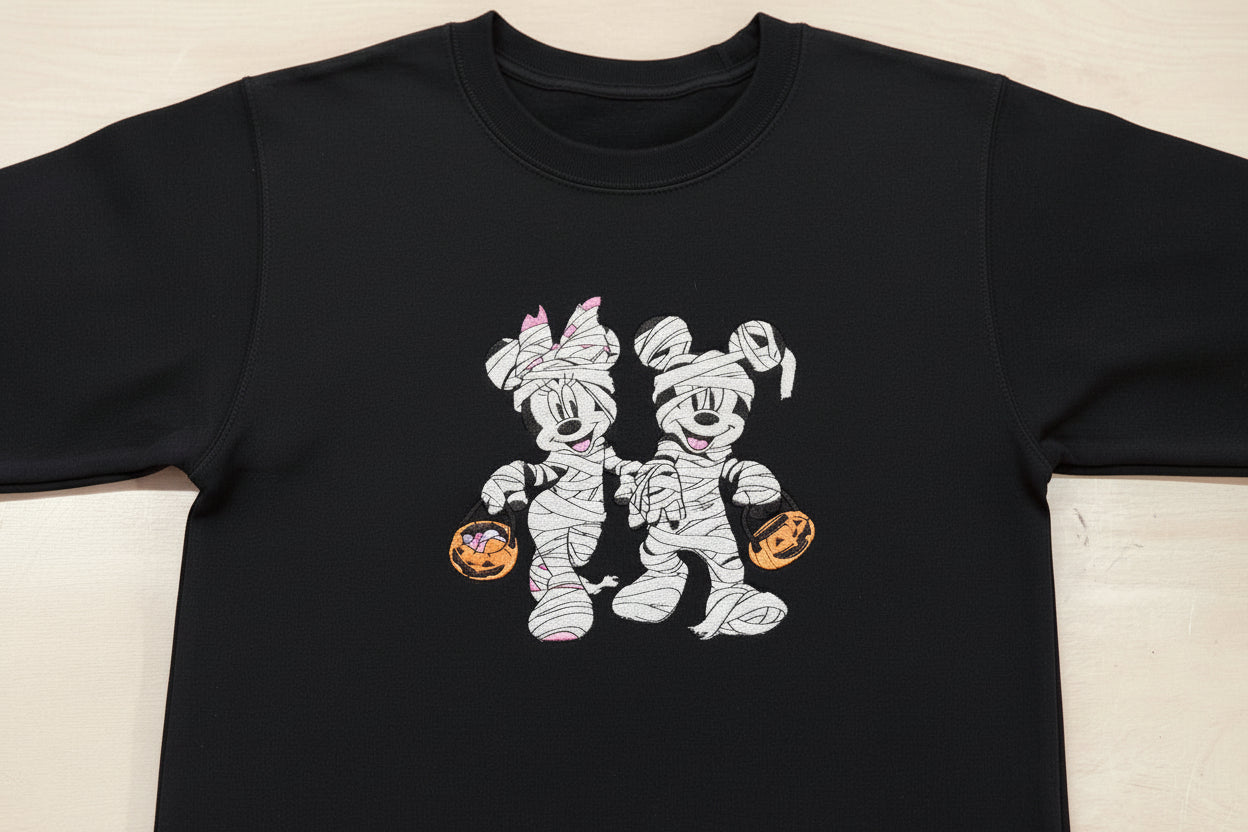 Halloween fun with our cozy embroidered sweatshirt featuring “Mickey & Minnie” all dressed up in their mummy costumes. Trick or Treat!