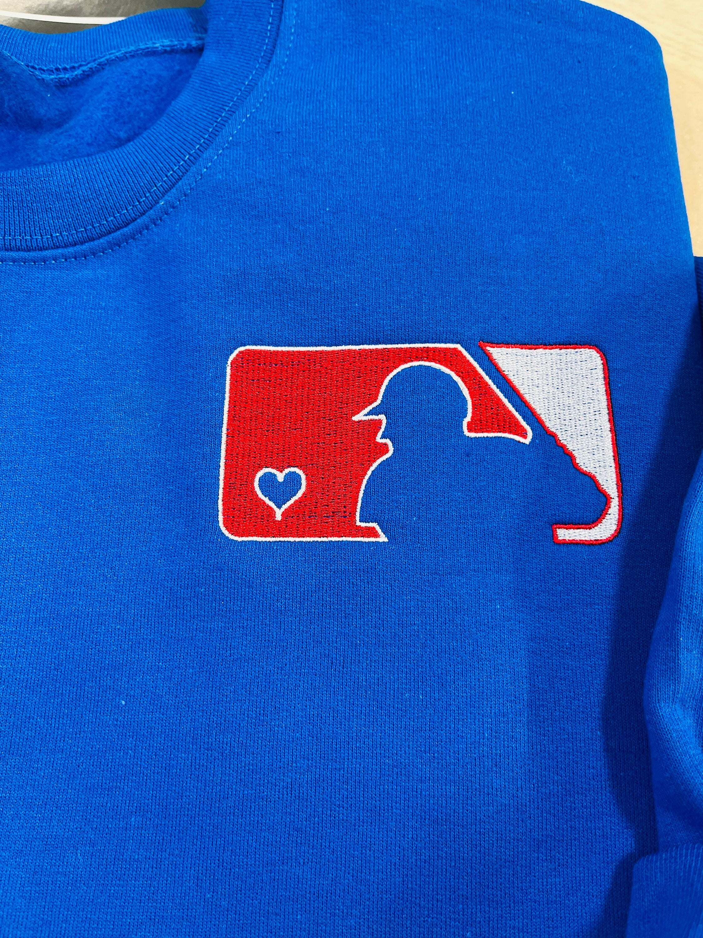 Love of Baseball Embroidered Sweatshirt. Classic outline of a baseball player and a heart logo is embroidered onto a soft & cozy sweatshirt.