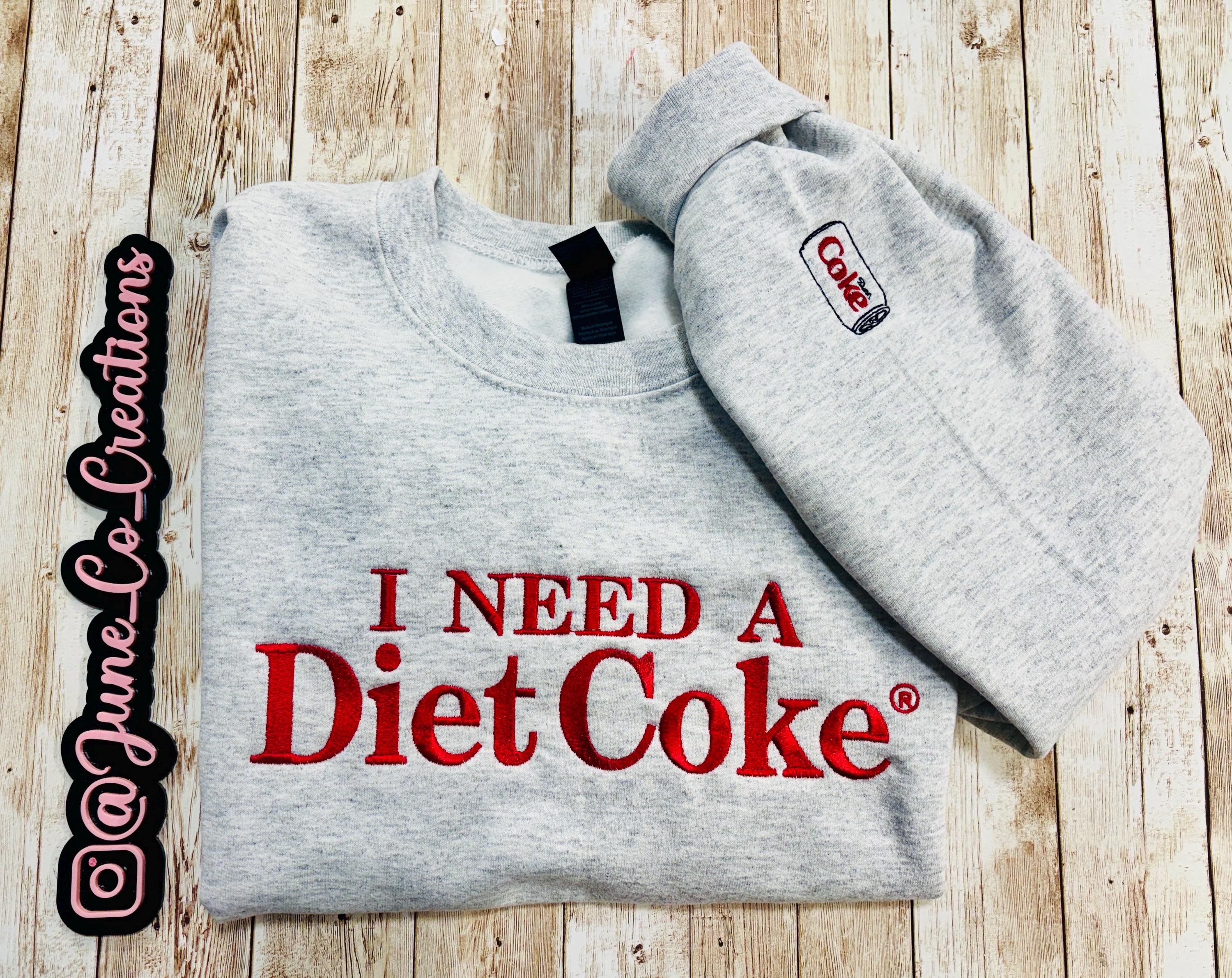 Diet Coke fans. I need a Diet Coke embroidered cozy sweatshirt comes with a mini sized Diet Coke on the sleeve.