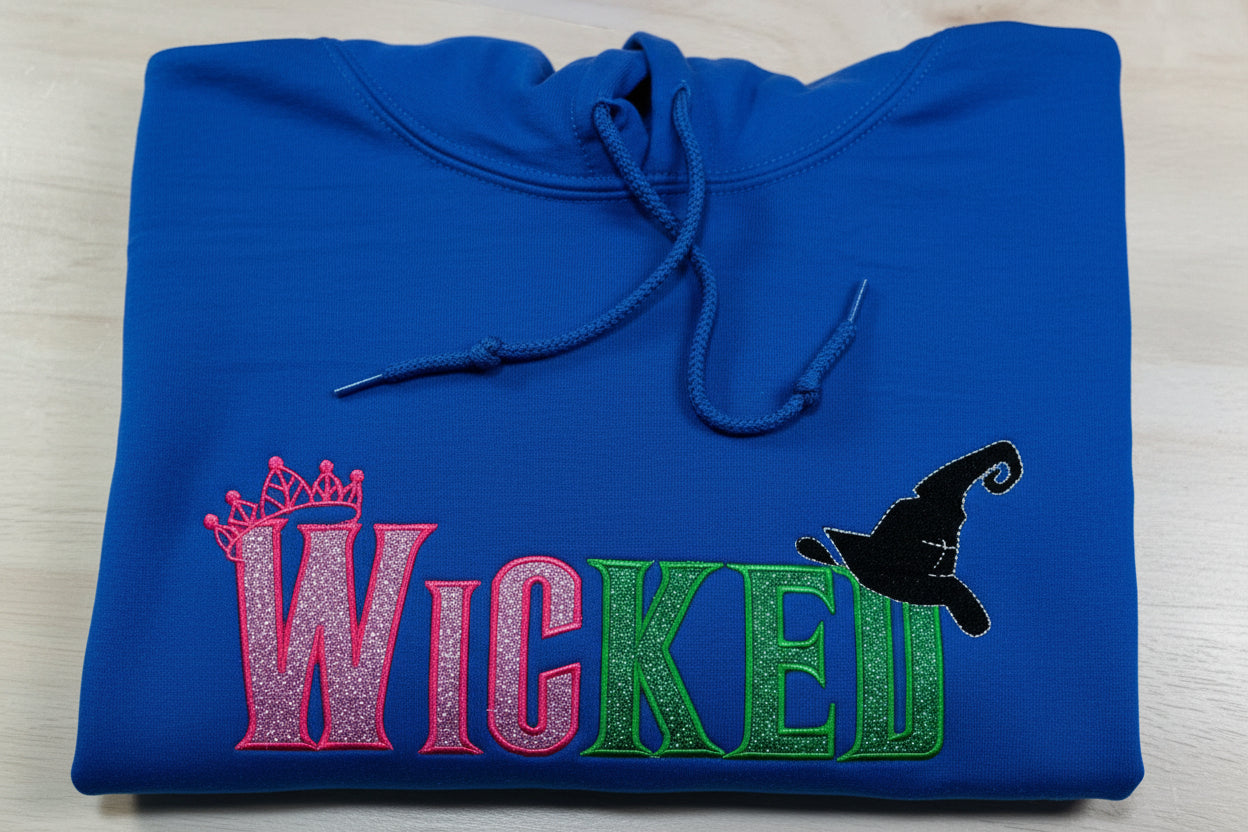 WICKED! This sparkly, embroidered wicked sweatshirt is perfect for Wicked fans. Includes a sleeve embellishment of a Green Broom/Pink Wand