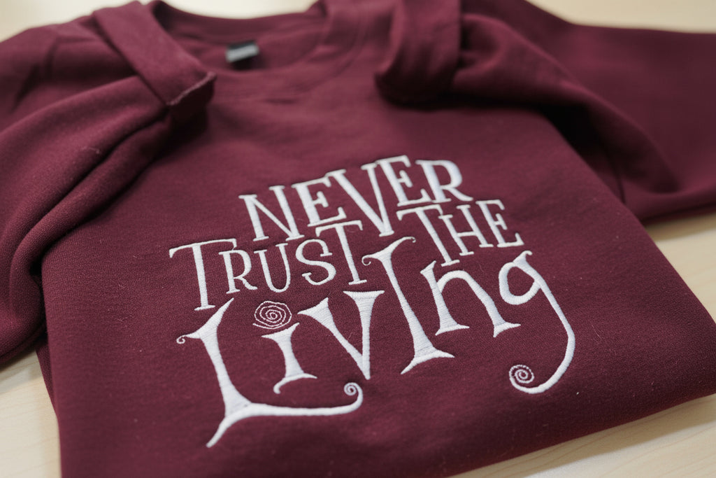 Coraline “Never Trust The Living” Season Embroidered Sweatshirt. Keeps you warm and cozy for those chilly nights.