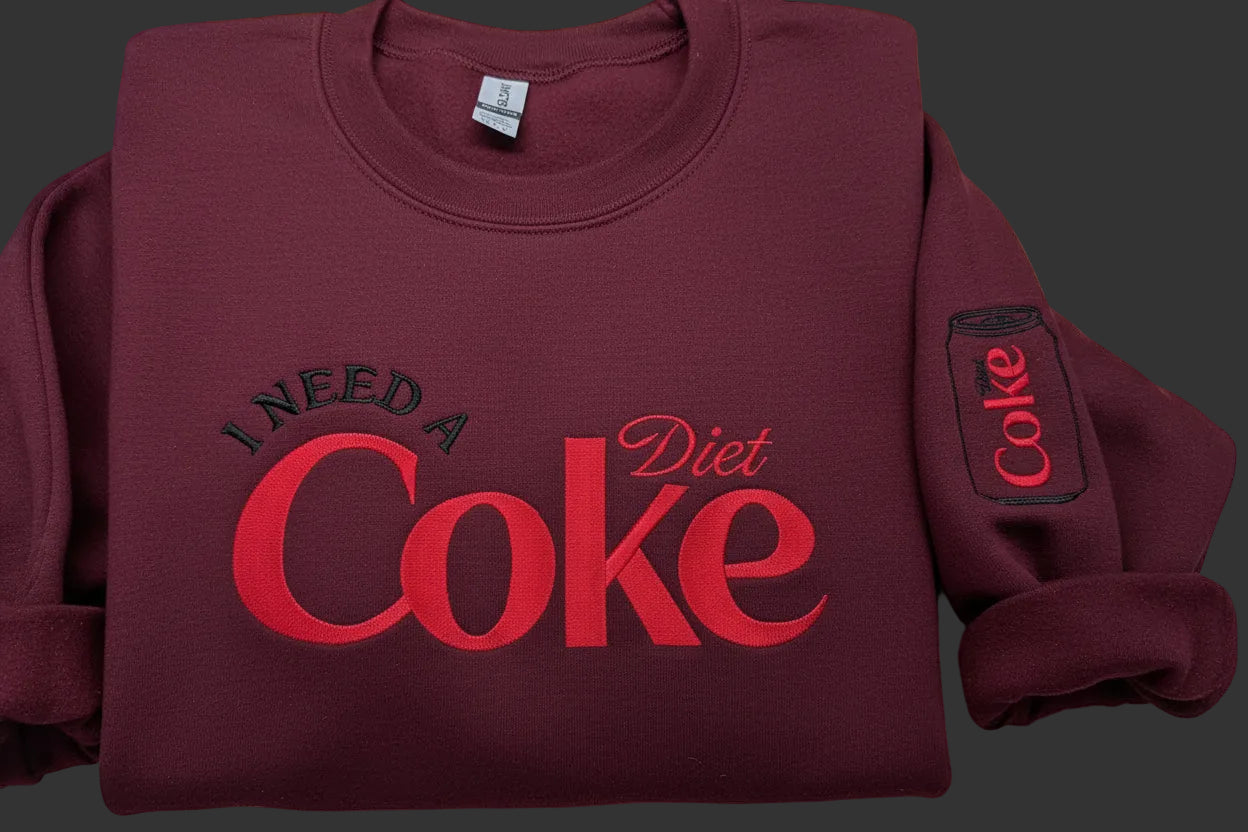 Diet Coke fans. I need a Diet Coke embroidered cozy sweatshirt comes with a mini sized Diet Coke on the sleeve.