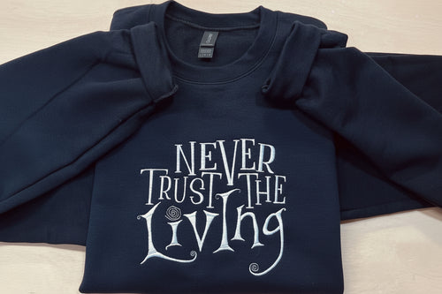 Coraline “Never Trust The Living” Season Embroidered Sweatshirt. Keeps you warm and cozy for those chilly nights.