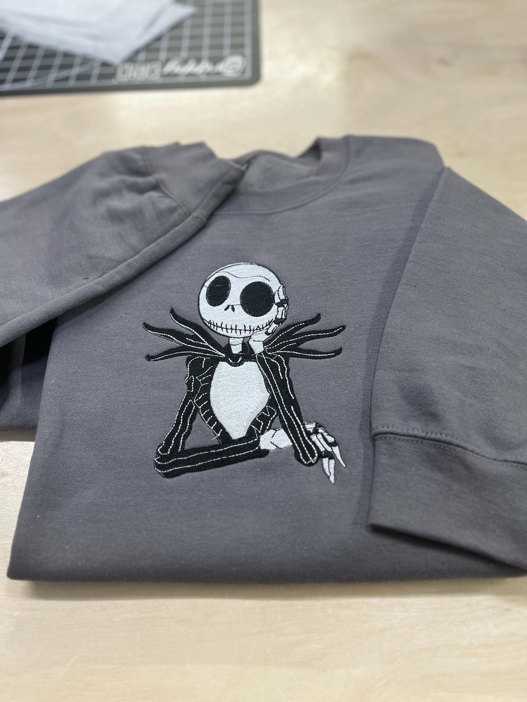 Celebrate the season with our cozy embroidered sweatshirt featuring Jack Skellington!