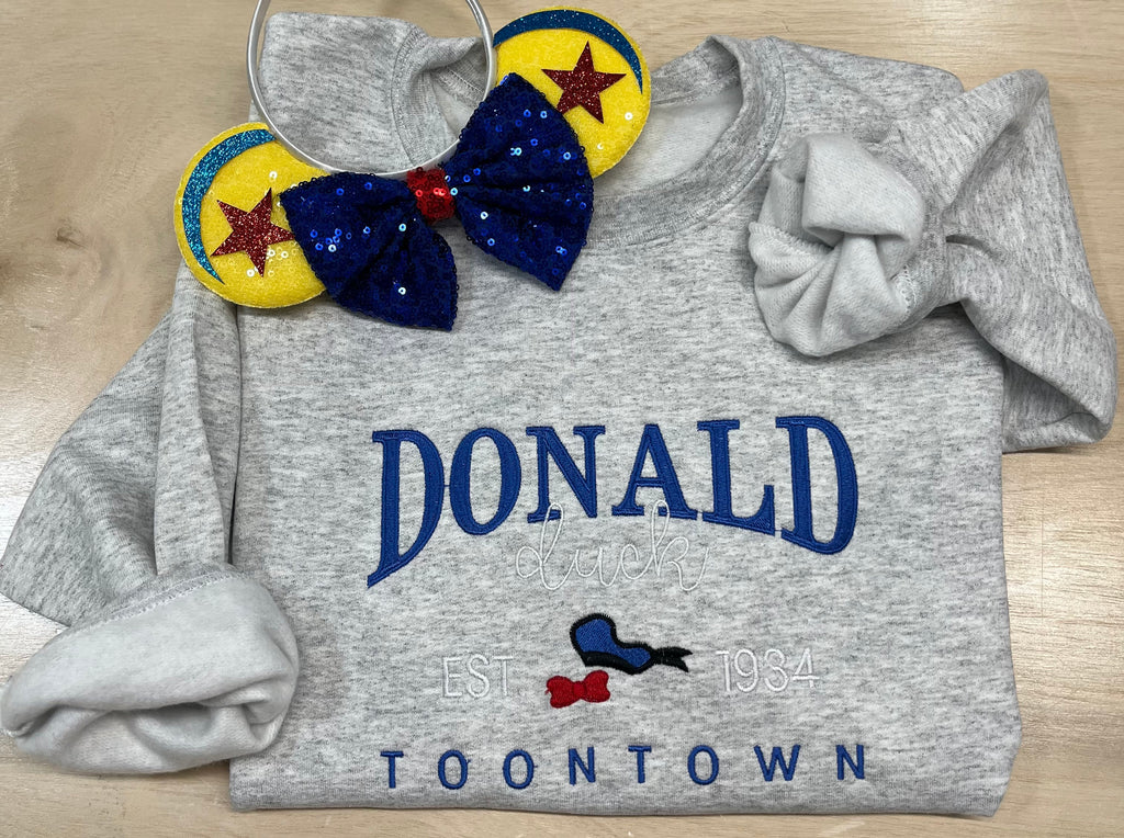 Donald Duck in Toontown. Disney Character embroidered onto a soft sweatshirt. Perfect for vacation or a unique gift for any Disney fan. Mickey and friends.