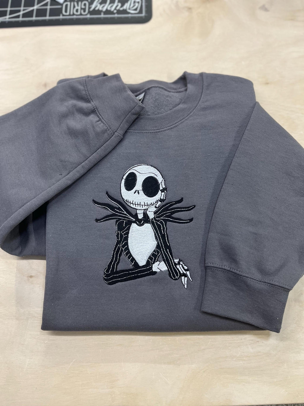 Celebrate the season with our cozy embroidered sweatshirt featuring Jack Skellington!