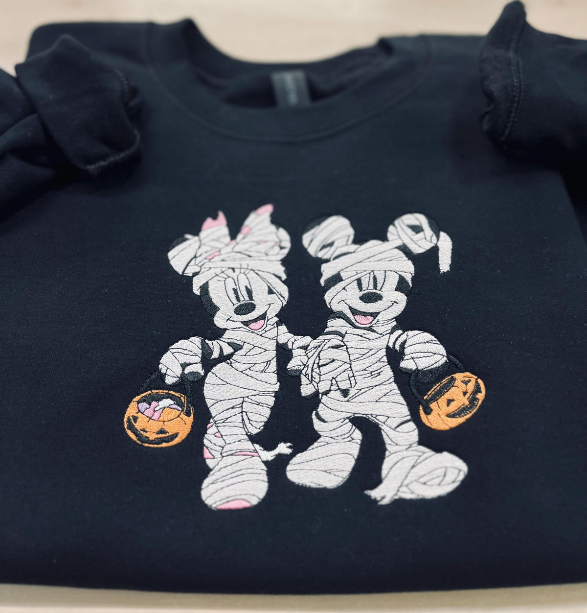 Halloween fun with our cozy embroidered sweatshirt featuring “Mickey & Minnie” all dressed up in their mummy costumes. Trick or Treat!