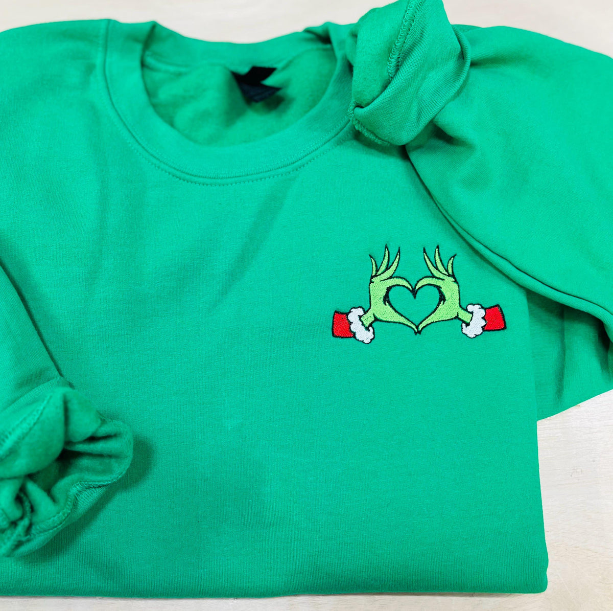 Show your Grinch Love with this Embroidered Sweatshirt. Featuring The Grinch hands shaped like a heart.