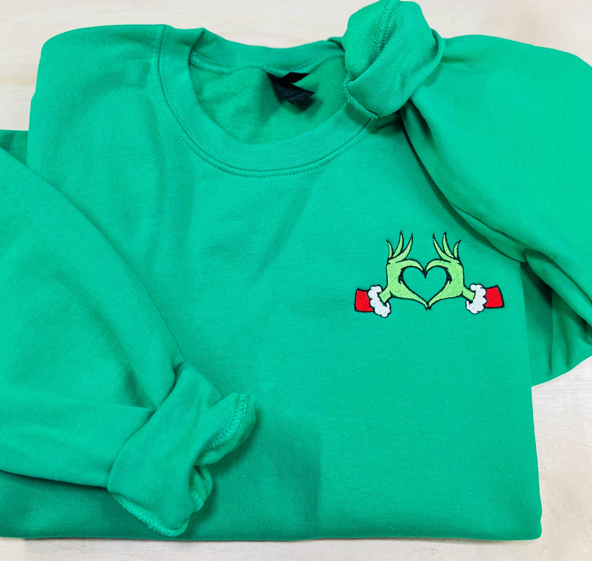 Show your Grinch Love with this Embroidered Sweatshirt. Featuring The Grinch hands shaped like a heart.