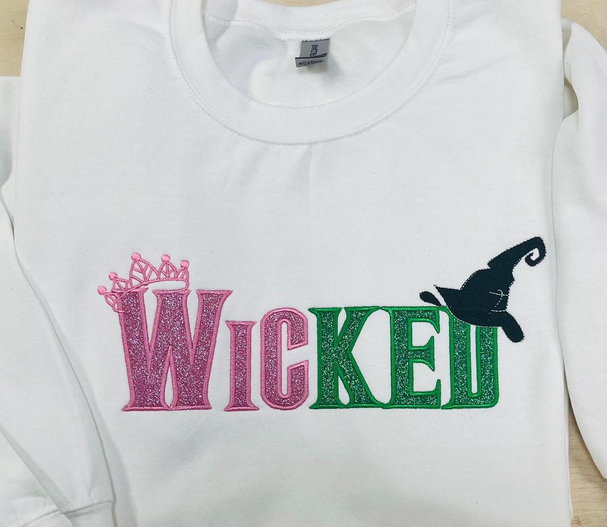 Youth WICKED! This sparkly, Wicked embroidered sweatshirt is perfect for Youth. Complete with sleeve embellishment Broom and Wand Vinyl