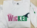 WICKED! This sparkly, embroidered wicked sweatshirt is perfect for Wicked fans. Includes a sleeve embellishment of a Green Broom/Pink Wand