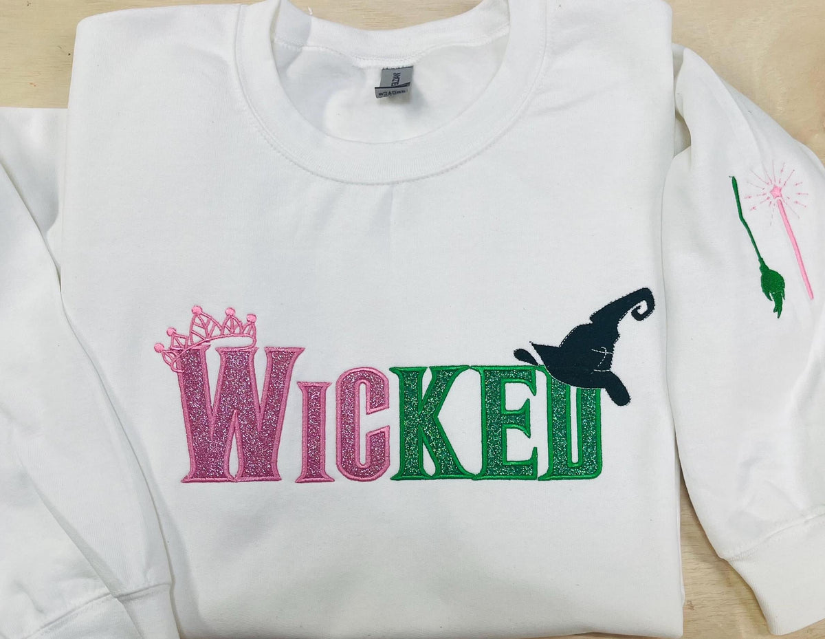WICKED! This sparkly, embroidered wicked sweatshirt is perfect for Wicked fans. Includes a sleeve embellishment of a Green Broom/Pink Wand