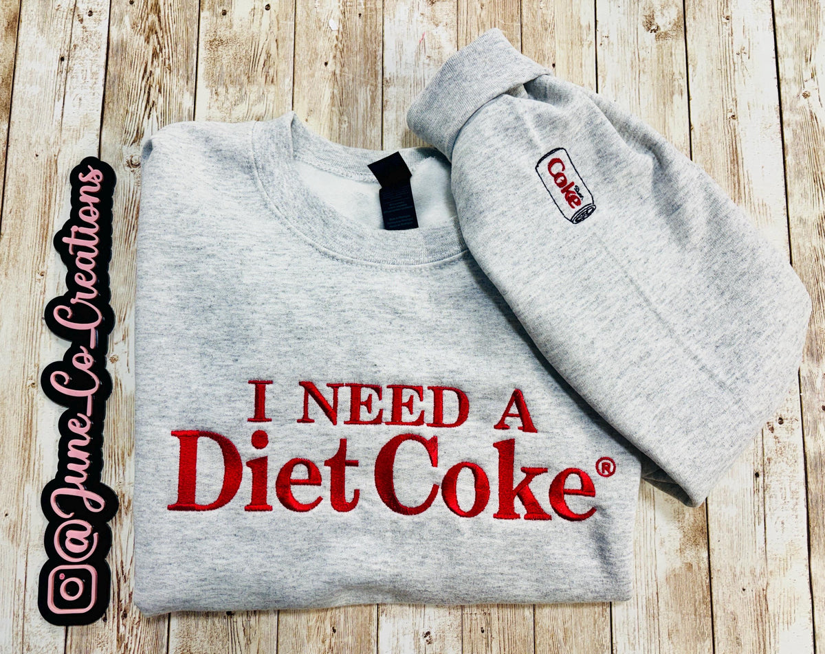 Diet Coke fans. I need a Diet Coke embroidered cozy sweatshirt comes with a mini sized Diet Coke on the sleeve.