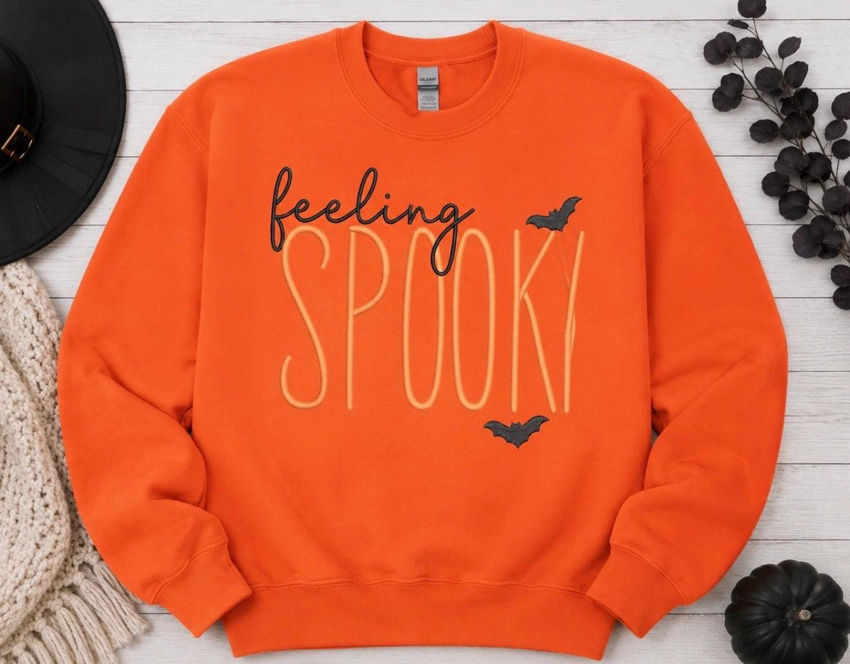 Celebrate the season with our cozy embroidered sweatshirt featuring “ feeling spooky” embellished with some bats