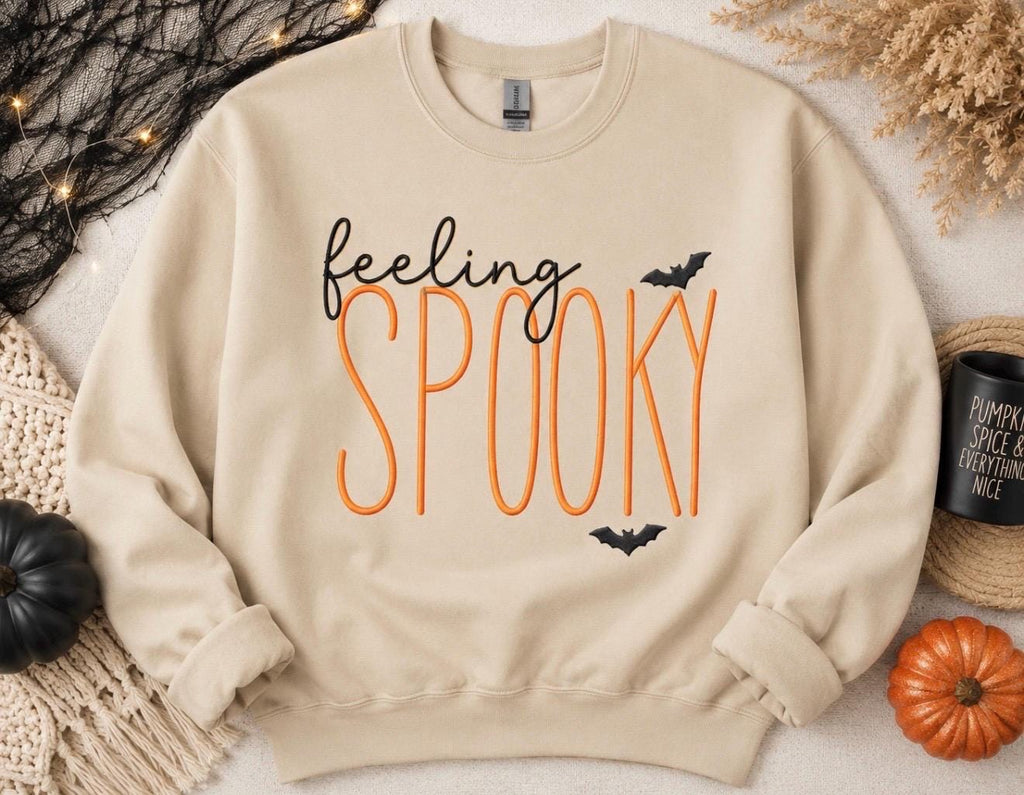 Celebrate the season with our cozy embroidered sweatshirt featuring “ feeling spooky” embellished with some bats