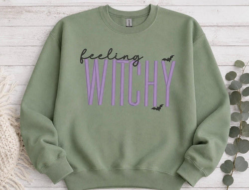 Celebrate the season with our cozy embroidered sweatshirt featuring “Feeling Witchy” embellished with some bats