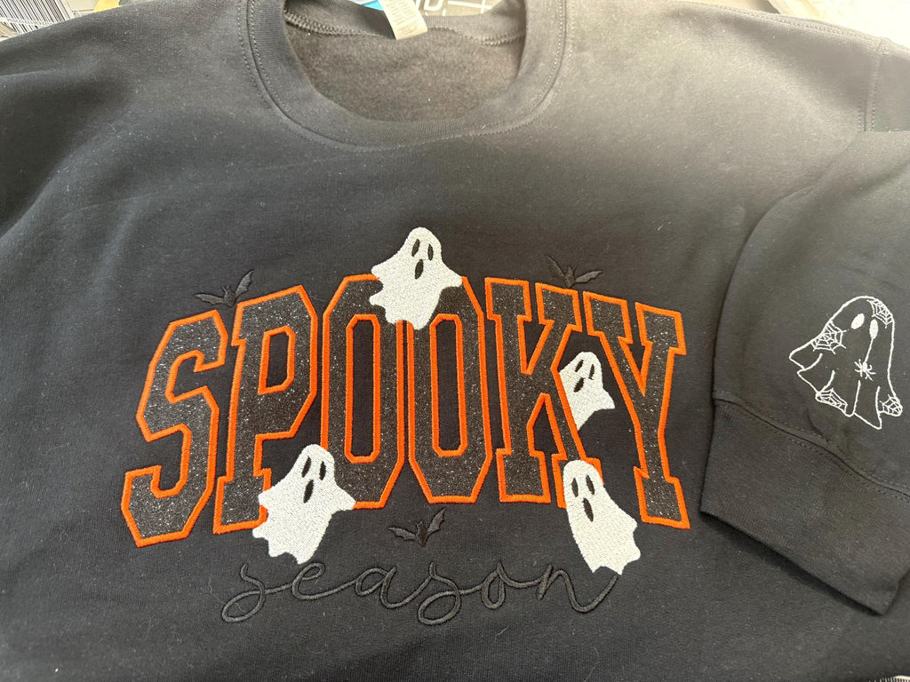 Spooky Season sparkly with our cozy embroidered sweatshirt featuring “spooky” embellished with some bats and ghosts.